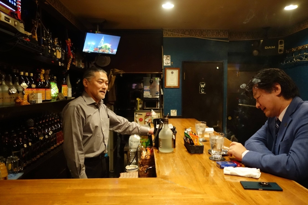 A snack bar tour guide typically escorts three to four people, taking them to two different snacks in one evening and quizzing the group on Japanese language and snack culture.