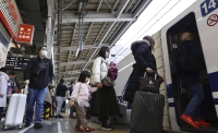 Passengers board a JR bullet train at Shin-Osaka Station on Wednesday. | KYODO