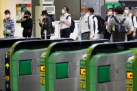 People wait for a train at Shinagawa Station in Tokyo. | REUTERS