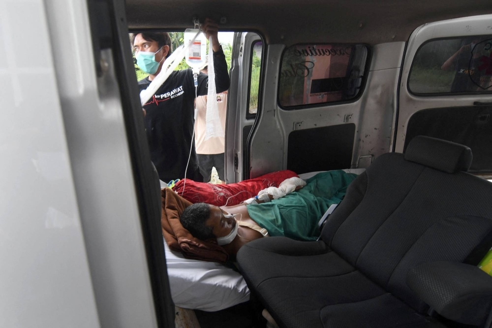 A victim of an explosion at a nickel smelter furnace owned by Indonesia Tsingshan Stainless Steel lies inside an ambulance at a hospital in Morowali, Indonesia, on Dec. 26. 