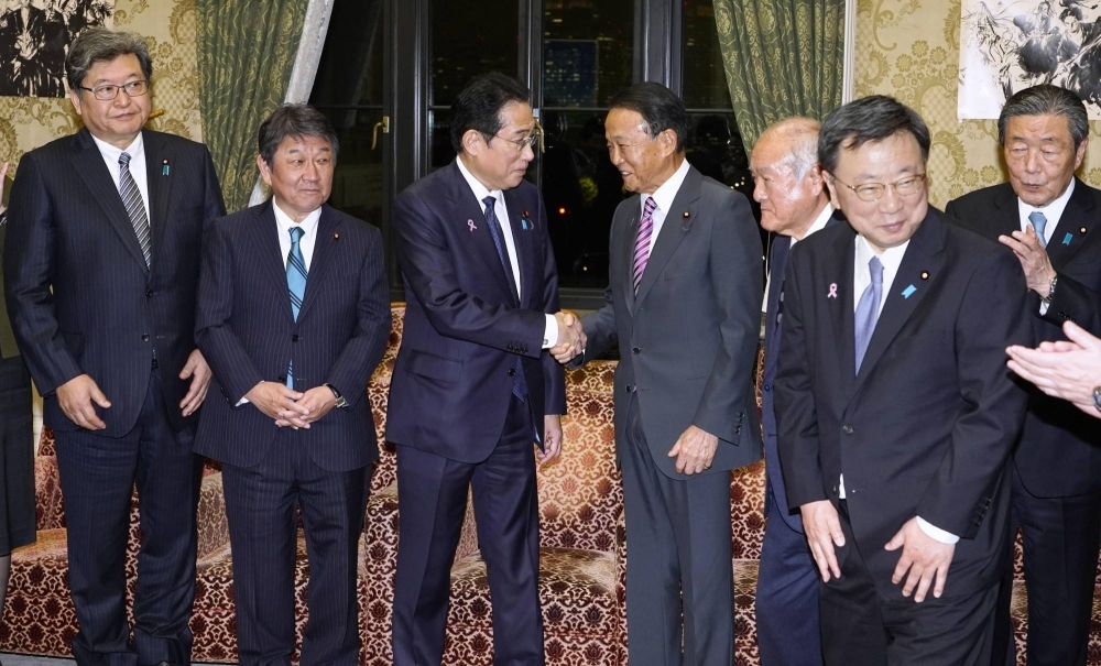 Prime Minister Fumio Kishida and Taro Aso, vice president of the Liberal Democratic Party, shake hands last November.  