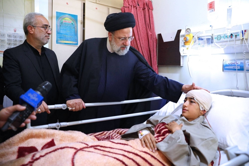 Iranian President Ebrahim Raisi visits the bedside of a person injured in Jan. 3 twin blasts in Kerman, at a hospital in the southern city.  