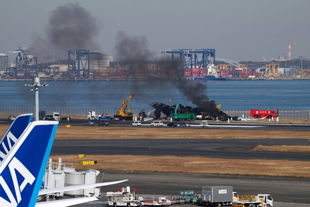 Smoke rises from the wreckage of a Japan Airlines passenger jet that collided Jan. 2 with a Japan Coast Guard plane at Haneda Airport in Tokyo.  