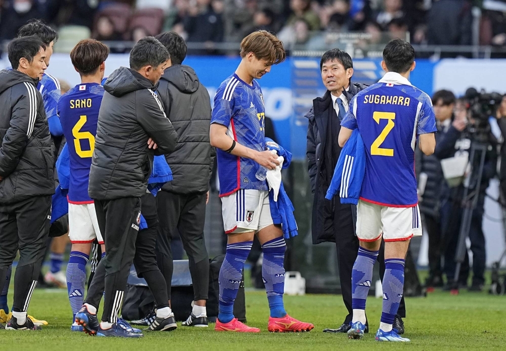 Japan manager Hajime Moriyasu (second from right) congratulates his players after they won an international friendly match against Thailand at Tokyo's National Stadium on Jan. 1.