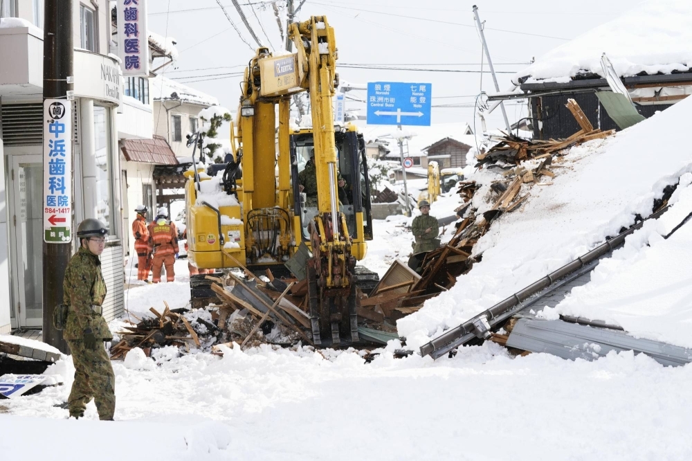 Self-Defense Force members use heavy machinery to remove debris from collapsed buildings in Suzu, Ishikawa Prefecture, on Monday.