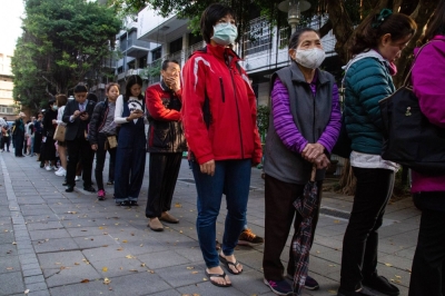 Voters wait in line outside a polling station during the last presidential and legislative elections, in Taipei in January 2020. Taiwan is one of only 53 political systems that require in-person voting.