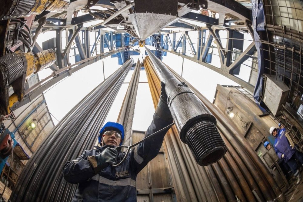 A worker guides drilling pipes on the Gazprom PJSC Chayandinskoye oil, gas and condensate field in Russia's Sakha Republic.