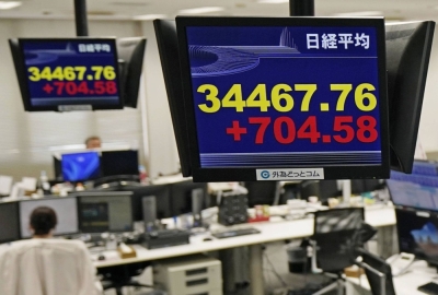 Monitors at a firm in Tokyo shows the 225-issue Nikkei average topping the 34,000 mark on Wednesday.