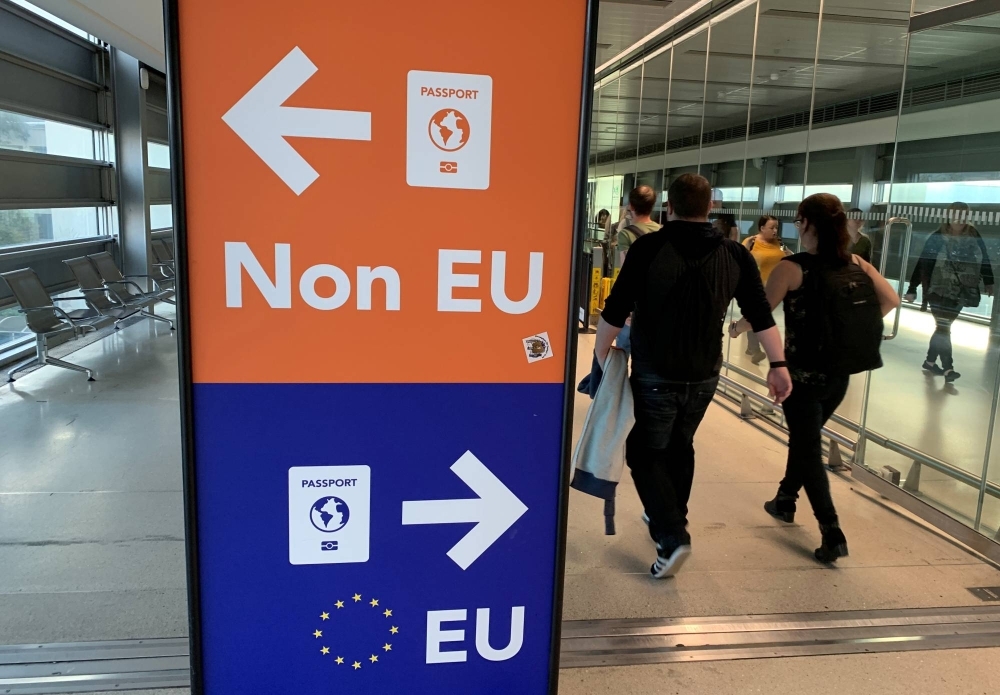 Passengers walk past a sign directing them to specific lines for EU and non EU passports as they arrive at Dublin Airport in Ireland in September 2019.