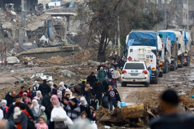 Palestinians fleeing northern Gaza move southward as trucks carrying aid and fuel head toward north Gaza during a temporary truce between Israel and Hamas, near Gaza City on Nov. 27.