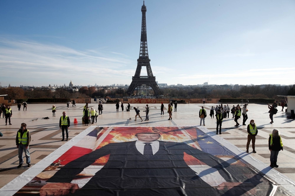 Climate activists install a portrait of French President Emmanuel Macron at Trocadero Square in front of the Eiffel tower to mark the fifth anniversary of the 2015 United Nations Paris Agreement, in December 2020.