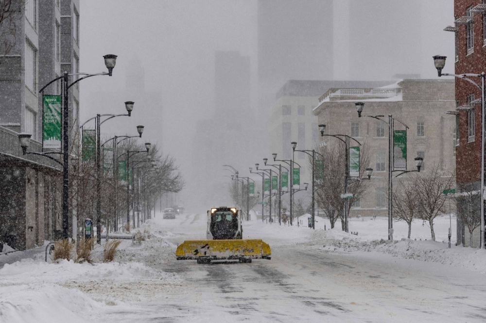 A snow plow drives down an empty street in Des Moines, Iowa, on Friday. 