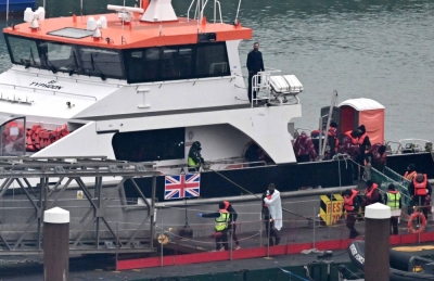 Migrants picked up at sea attempting to cross the English Channel from France disembark from a U.K. border force cutter in Dover, England, on Saturday. 