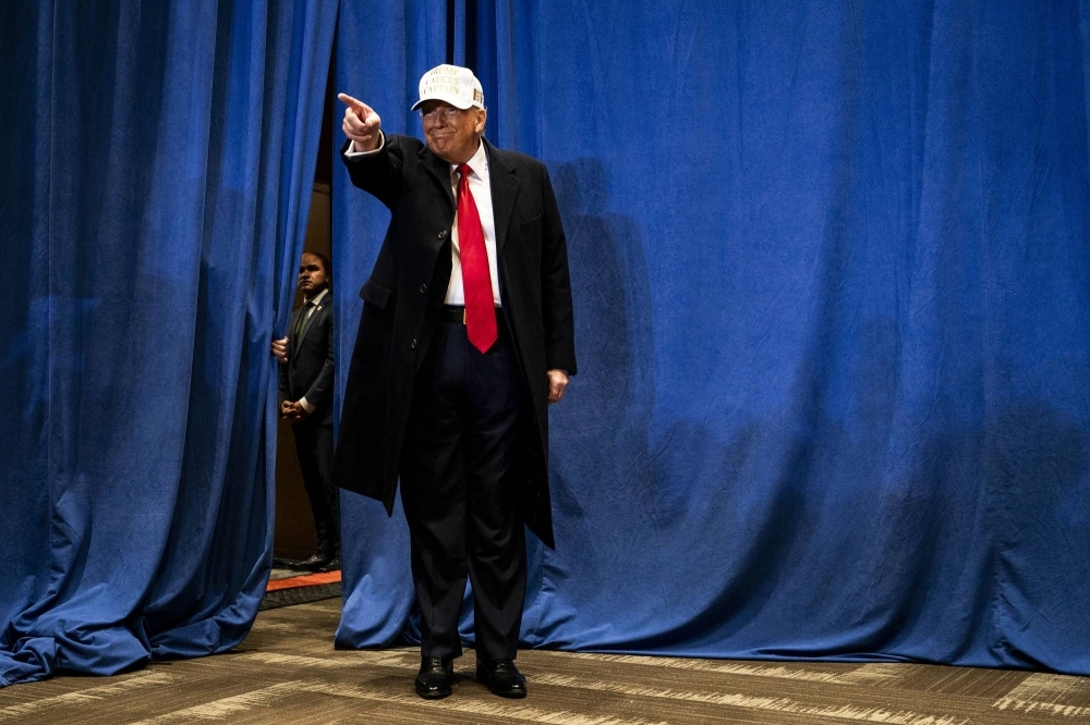 Former U.S. President Donald Trump greets attendees at a campaign rally in Indianola, Iowa, on Sunday.