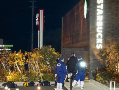 Police officers examine the area around a Starbucks outlet at the Aeon Town Kawanoe shopping facility in Shikokuchuo, Ehime Prefecture, on Sunday night after a shooting incident at the store.