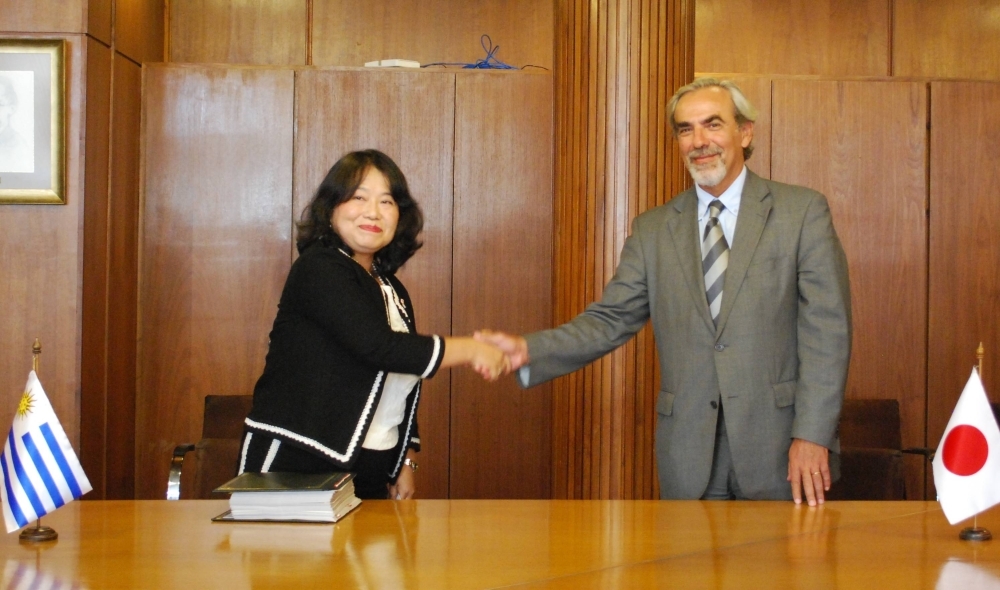 Tanaka takes part in a signing ceremony for the Japan-Uruguay Investment Agreement with Uruguay's Acting Minister of Foreign Affairs Luis Porto in 2015.