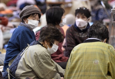 People wear masks at an evacuation center in the town of Anamizu, Ishikawa Prefecture, on Jan. 8. The number of people with acute respiratory infectious diseases, which include COVID-19 and influenza, at evacuation centers in the prefecture stood at 142 as of Sunday.