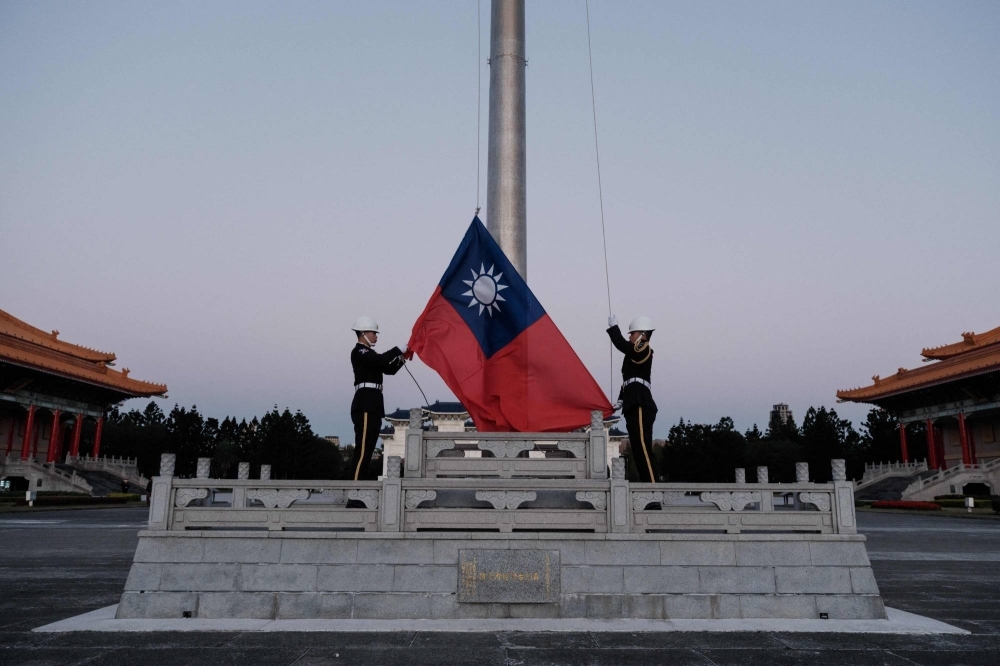 Guards raise Taiwan's national flag on the Democracy Boulevard at the Chiang Kai-shek Memorial Hall in Taipei on Sunday.