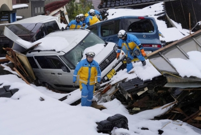 Police officers search for victims in a snow covered residential area which was devastated by a tsunami following an earthquake, in Suzu, Ishikawa Prefecture, on Jan. 9.