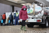 Residents receive water in Shika, Ishikawa Prefecture, on Monday. | Jiji