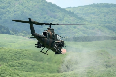 A Ground Self-Defense Force AH-1S Cobra attack helicopter fires ammunition during a live-fire exercise in Gotemba, Shizuoka Prefecture, in May 2022.
