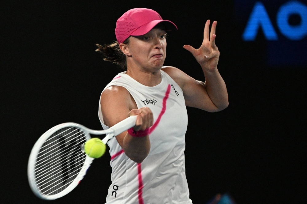 Iga Swiatek hits a return against Danielle Collins during their second-round match at the Australian Open in Melbourne on Thursday.