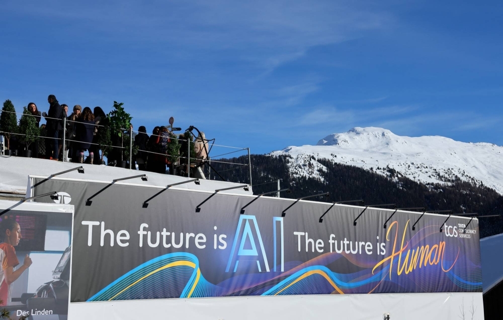 People gather on top of Tata Consultancy Services pavilion on which a slogan related to Artificial Intelligence (AI) is displayed, during the 54th annual meeting of the World Economic Forum in Davos, Switzerland,on Tuesday. 