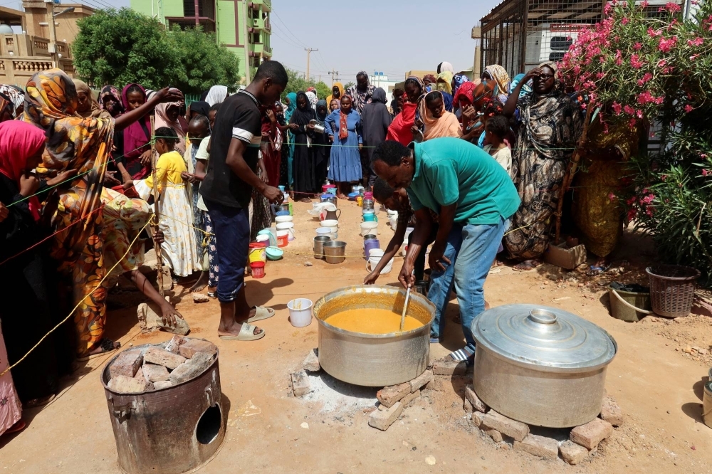 A volunteer stirs food to be distributed to people in Omdurman, Sudan, in September 2023.
