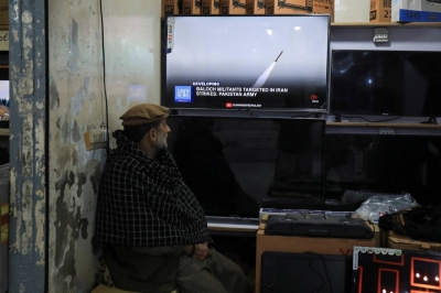 A man watches the news on television showing the Pakistani foreign ministry's statement about the country's strikes inside Iran targeting separatist militants, in Peshawar, Pakistan on Thursday.