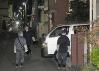 Police investigators conduct an on-site inspection Thursday at a house in Tokyo's Adachi Ward where two bodies had been found. | Kyodo