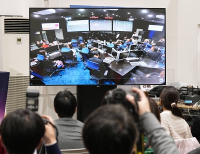 A screen shows JAXA officials in the mission control room at the space agency's campus in Sagamihara, Kanagawa Prefecture, on Saturday. 
