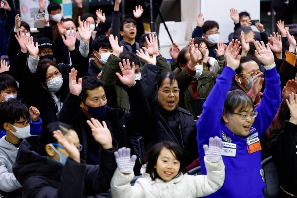 People celebrate after a successful moon landing by the Smart Lander for Investigating Moon, at a public viewing event in Sagamihara, Kanagawa Prefecture, on Saturday.