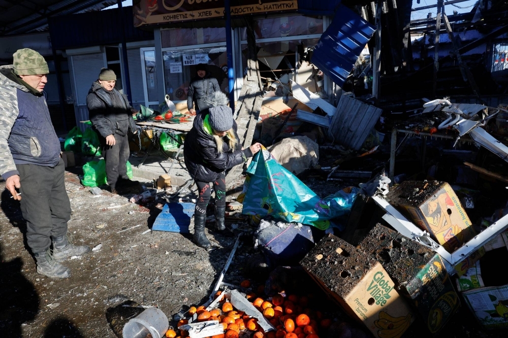 People remove debris at a food market following what local Russian-installed authorities said was a Ukrainian military strike in Donetsk, on Sunday.