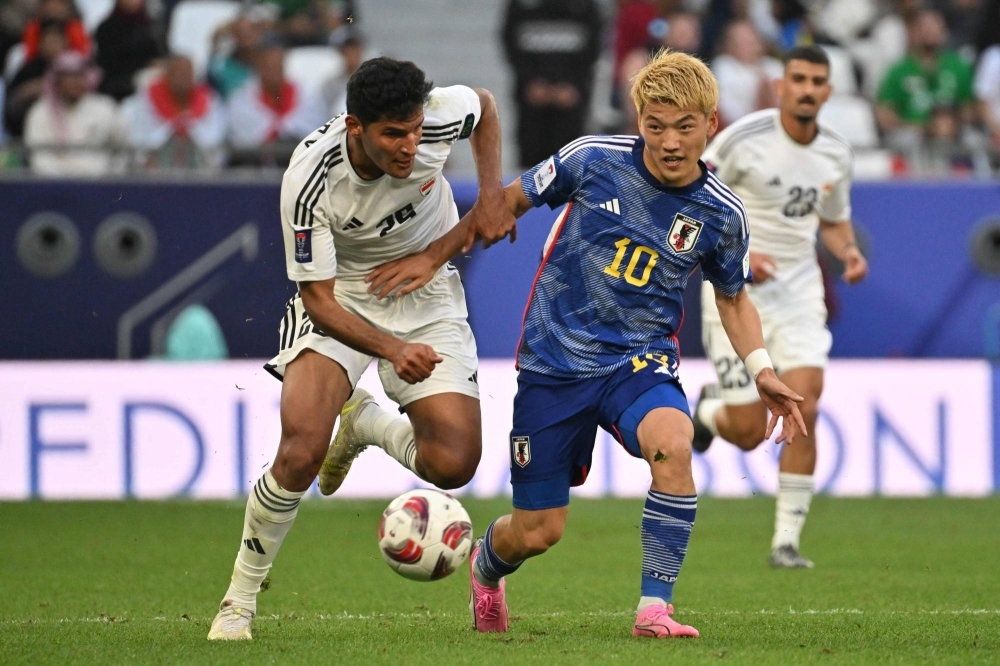 Iraq's Ahmed Yahya (left) and Japan's Ritsu Doan fight for the ball during their match at the Asian Cup on Friday.