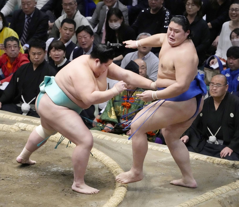 Kotonowaka (left) pushes Onosato out of the ring on Tuesday night at Ryogoku Kokugikan in Tokyo.