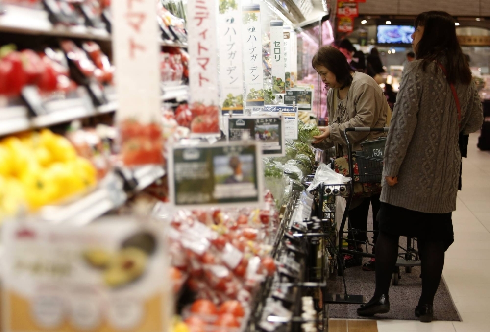 Shoppers browse vegetables at a supermarket in Chiba. Sales at all supermarkets totaled ¥13.56 trillion, with price hikes in food items boosting overall sales despite shoppers buying fewer items, according to the Japan Chain Stores Association.