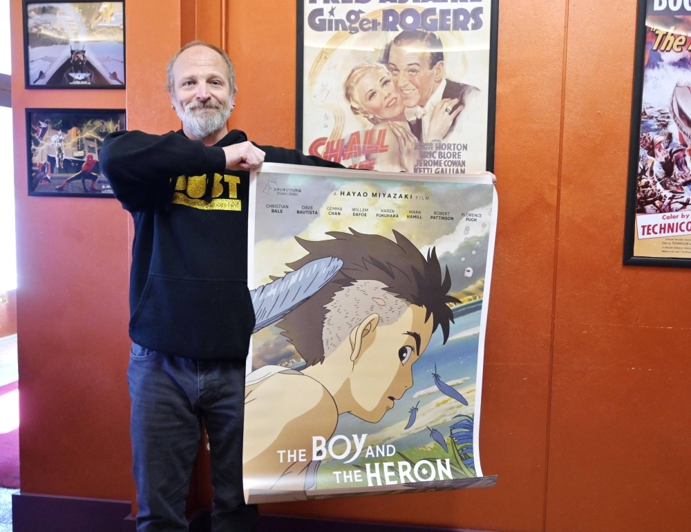 A man holds a poster for "The Boy and the Heron" at a movie theater in New Mexico in December. 