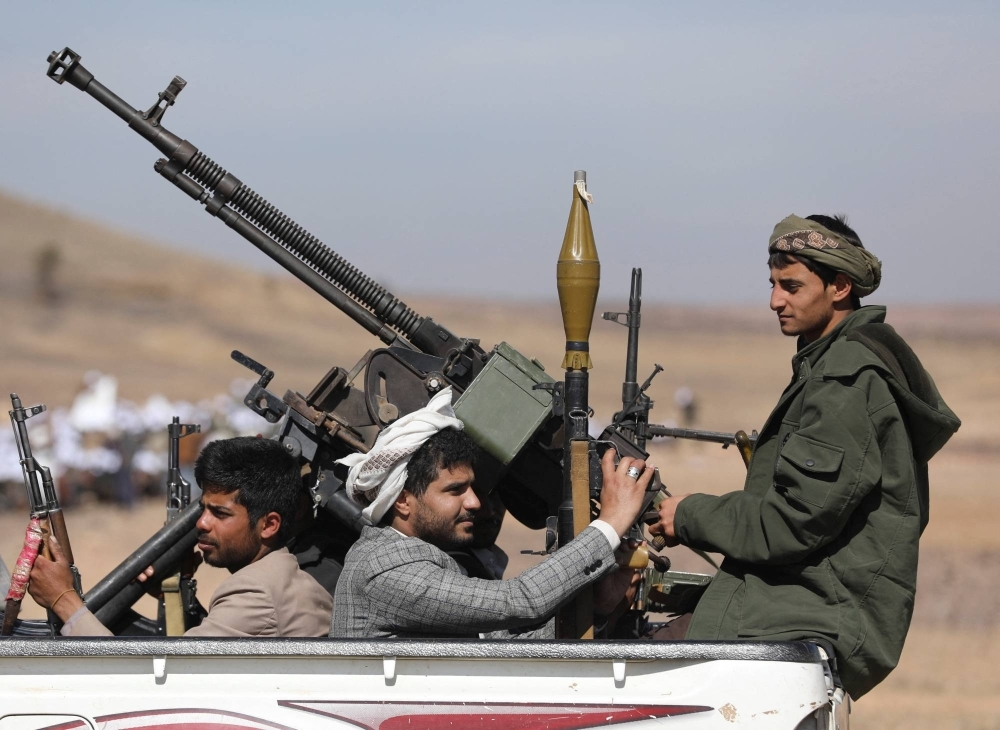 Fighters loyal to the Houthis ride on the back of a pick-up truck during a military parade for new tribal recruits amid escalating tensions with the U.S.-led coalition in the Red Sea, in Bani Hushaish, Yemen on Monday.
