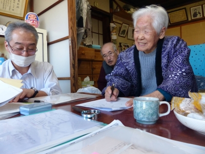 Shitsui Hakoishi, 107, works with researcher Yasumichi Arai (left) while her younger brother, Hidemasa, looks on. Researchers like Arai believe the healthy and active Hakoishi's cells may hold the secret to living a long life. 