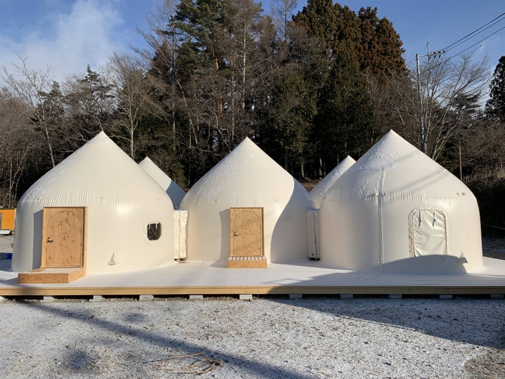 The Instant House's pointed roof prevents snow accumulation, while a side slot allows power cables to be pushed inside for lighting and heaters.
