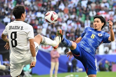 Japan's Takumi Minamino (right) and Iraq's Ibrahim Bayesh vie for the ball during their Asian Cup match in Doha on Jan. 19.