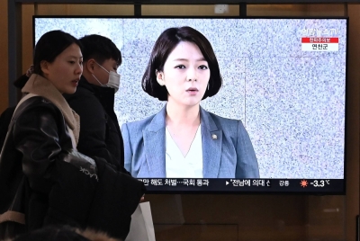 People walk past a television screen showing a broadcast with file footage of South Korean lawmaker Bae Hyun-jin, at a railway station in Seoul on Thursday.