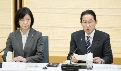 Prime Minister Fumio Kishida addresses a meeting of the government's Tax Commission at the Prime Minister's Office on Thursday, as the commission's new chief Yuri Okina looks on.