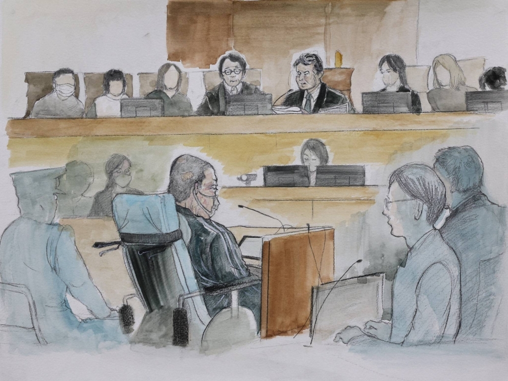 A courtroom sketch shows Shinji Aoba (center) listening to a ruling handed down at the Kyoto District Court on Thursday. 
