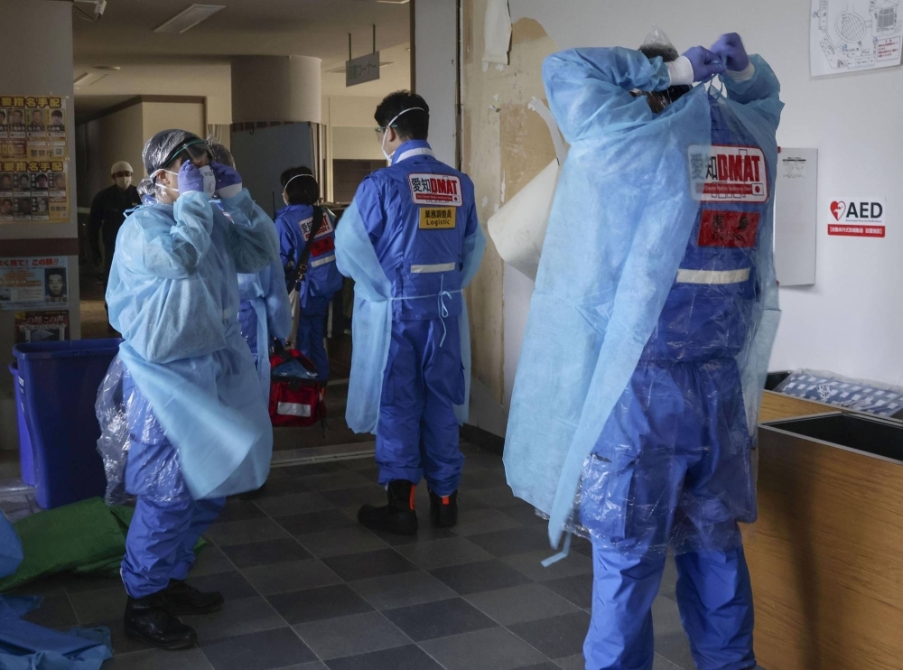 Medical workers prepare to enter an evacuation center in Anamizu, Ishikawa Prefecture, where COVID-19 infections were confirmed on Jan. 6.