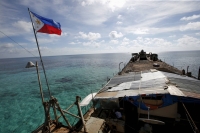 A Philippine flag flutters from BRP Sierra Madre, a dilapidated Philippine Navy ship that has been aground since 1999 and become a Philippine military detachment on the disputed Second Thomas Shoal, part of the Spratly Islands, in the South China Sea in March 2014. | REUTERS