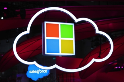 The Microsoft logo hangs beside an illuminated iCloud icon at the CeBIT 2017 tech fair in Hannover, Germany.