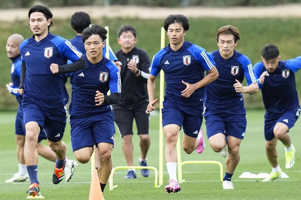 Japan's Takumi Minamino (front left) trains alongside his teammates in Doha on Monday.