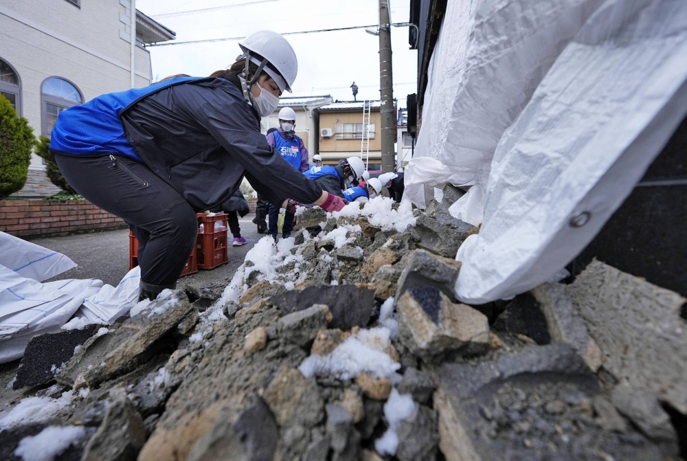 Volunteers work at the site of a soy sauce-maker in Nanao, Ishikawa Prefecture, on Saturday.