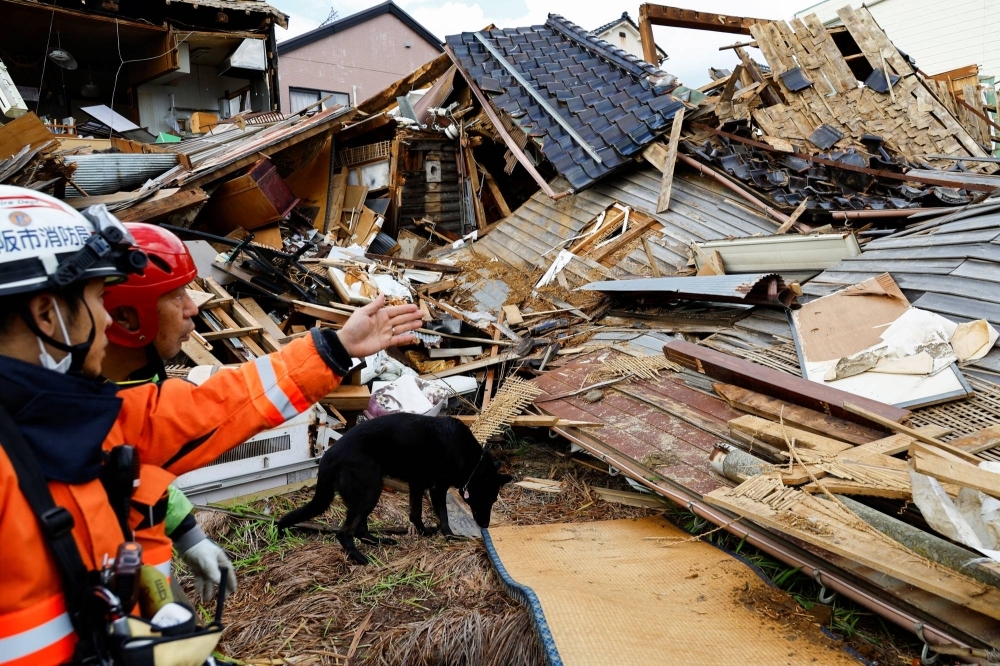 Rescue workers look for missing people in collapsed houses in the aftermath of the  earthquake that struck Wajima, Ishikawa Prefecture, and the surrounding areas on Jan. 1.  